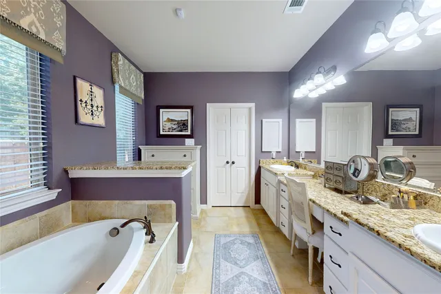 a spacious bathroom with a granite countertop tub sink and mirror