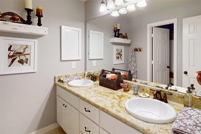 a bathroom with double vanity sinks a mirror and a lamp