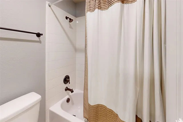 a bathroom with a sink a toilet and a shower curtain