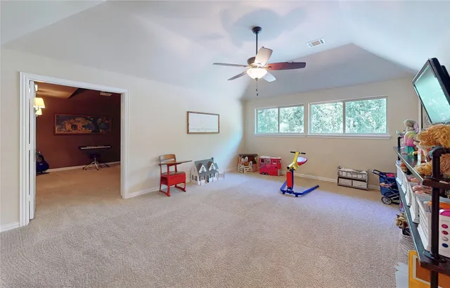 a view of a room with furniture and a ceiling fan