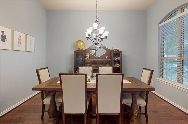 a view of a dining room with furniture a chandelier and wooden floor
