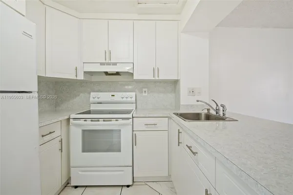 a kitchen with cabinets appliances a sink and a counter top space
