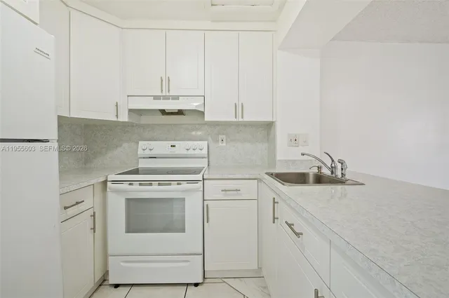 a kitchen with cabinets appliances a sink and a counter top space