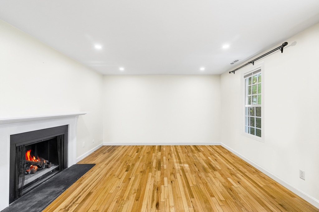 24 Jericho Road, Unit 24 Weston, MA 02493 - Photo 12 of 36 a view of empty room with wooden floor and fireplace