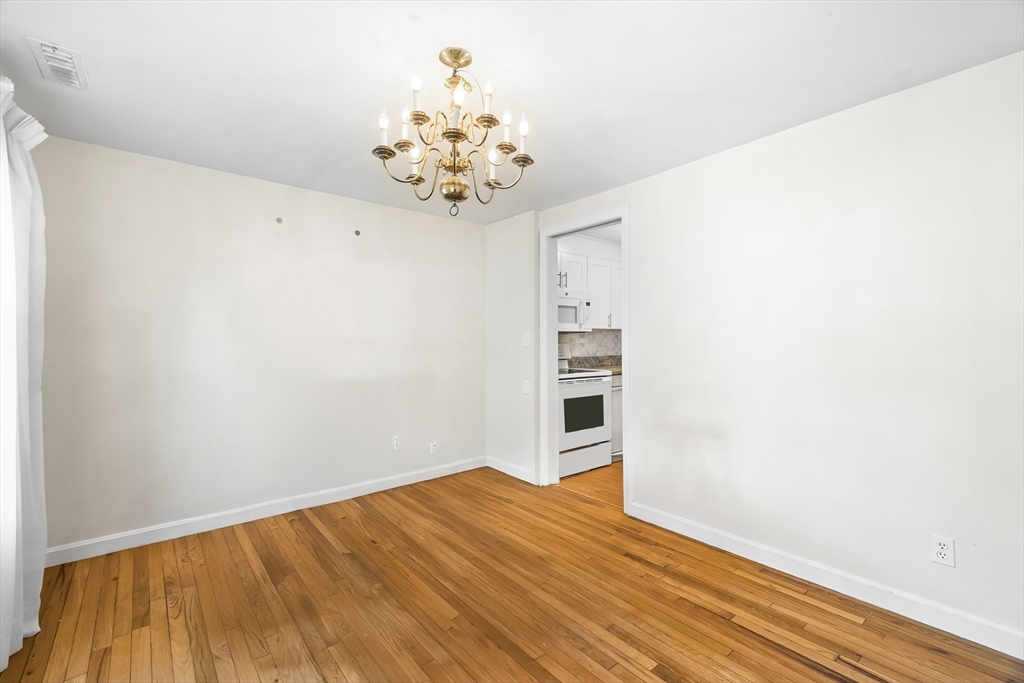 24 Jericho Road, Unit 24 Weston, MA 02493 - Photo 5 of 36 a view of a room with wooden floor and chandelier