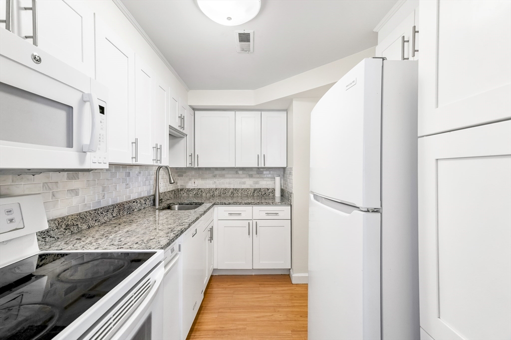 24 Jericho Road, Unit 24 Weston, MA 02493 - Photo 9 of 36 a kitchen with a sink stove and refrigerator