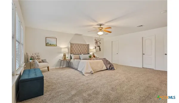 a spacious bedroom with a bed and a chandelier