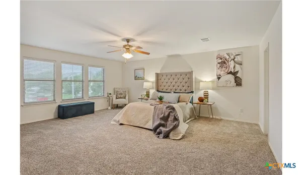 a spacious bedroom with a bed and a large window