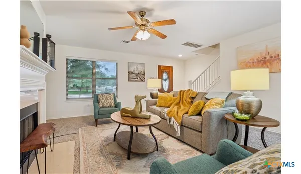 a living room with furniture fireplace and a window