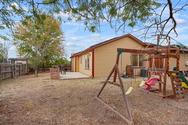 a view of a house with a backyard and a tree