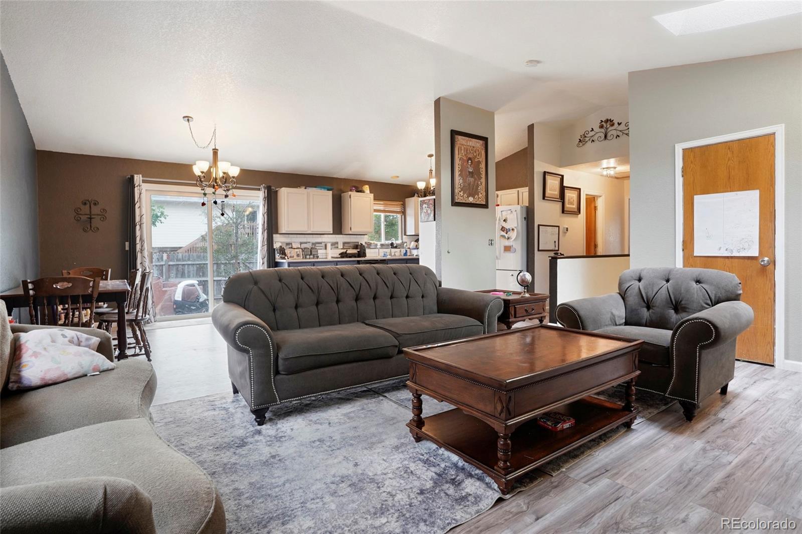 1200 7th Street Fort Lupton, CO 80621 - Photo 2 of 17 a living room with furniture and a chandelier