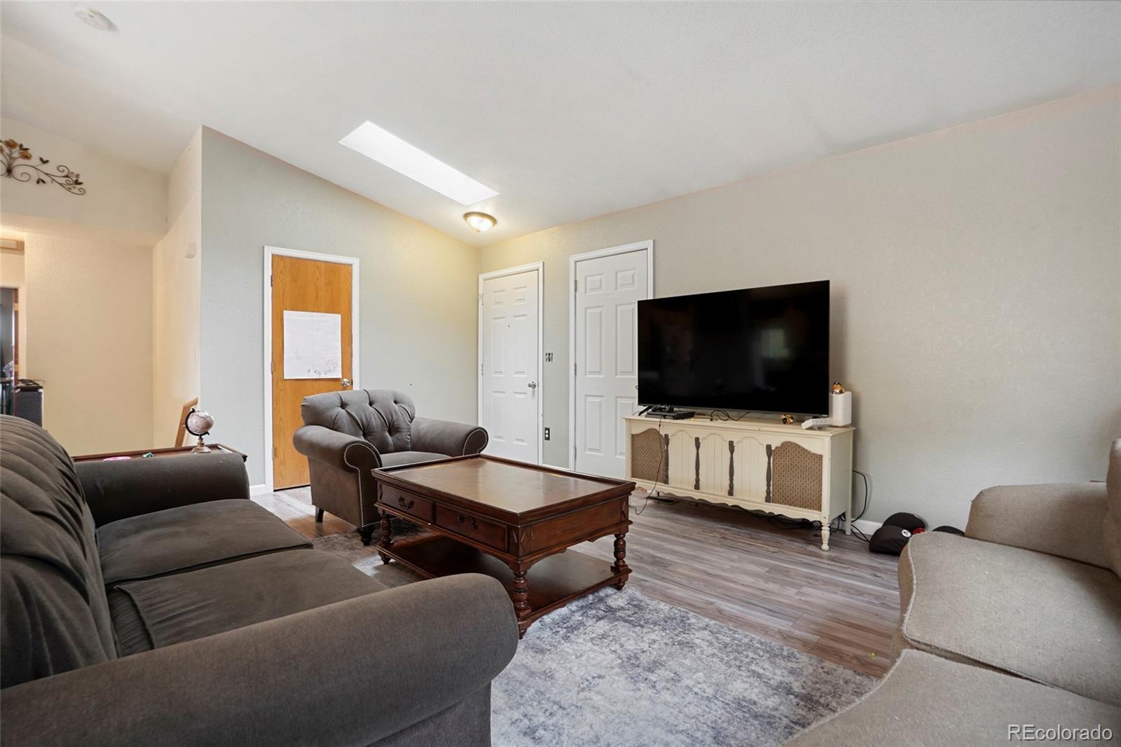 1200 7th Street Fort Lupton, CO 80621 - Photo 5 of 17 a living room with furniture and a flat screen tv