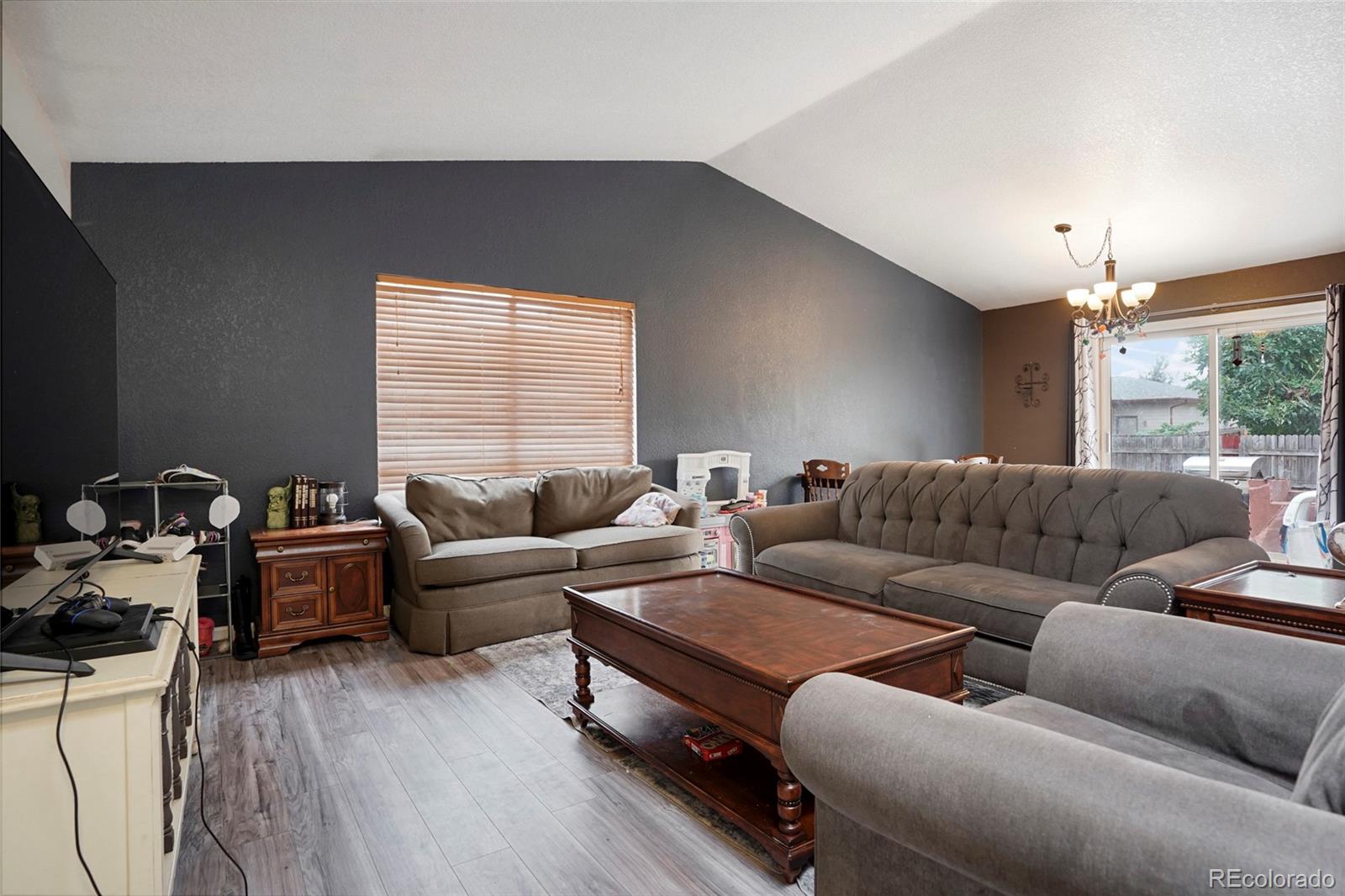 1200 7th Street Fort Lupton, CO 80621 - Photo 6 of 17 a living room with furniture a chandelier and a window