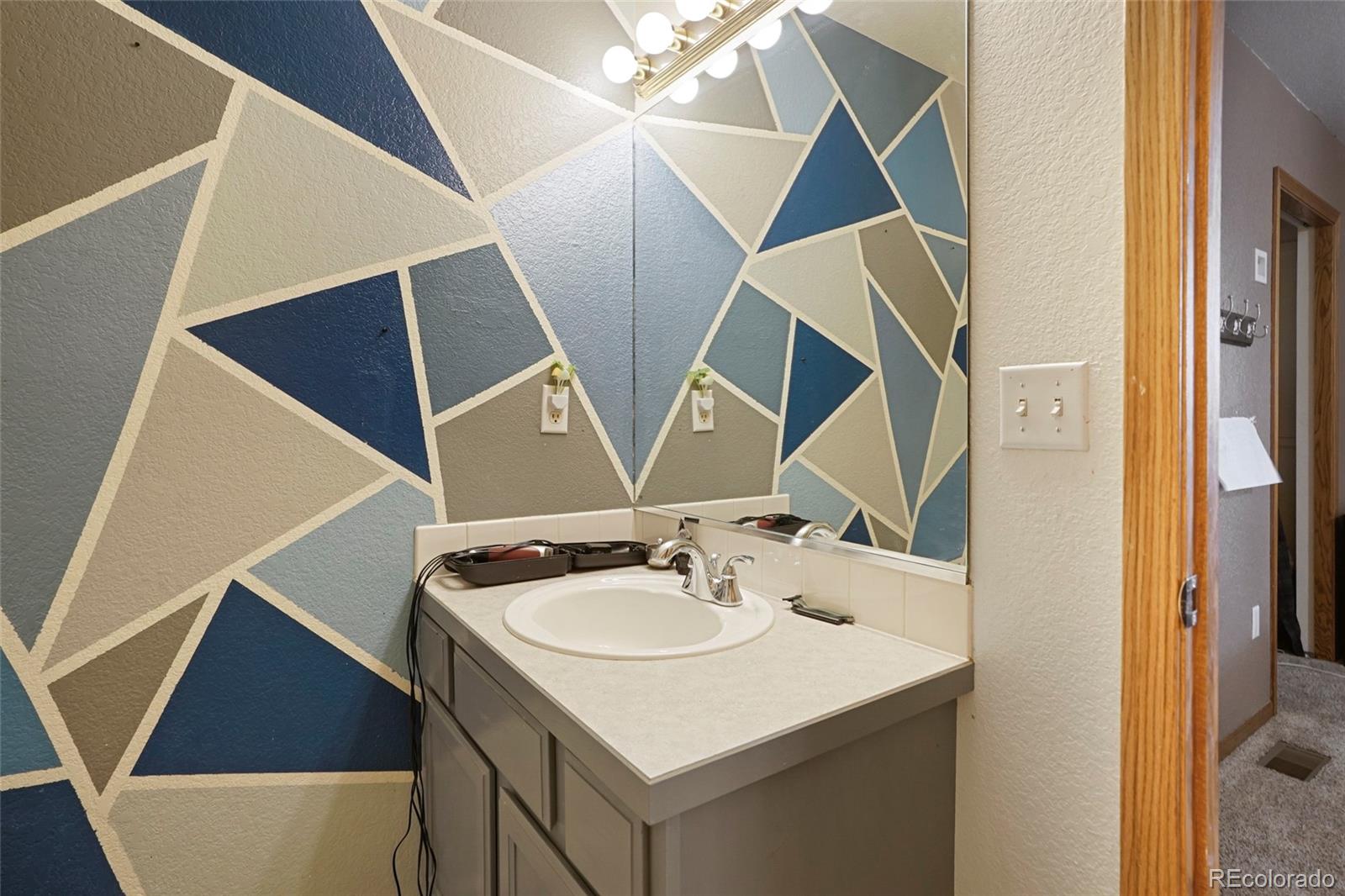 1200 7th Street Fort Lupton, CO 80621 - Photo 10 of 17 a bathroom with a sink and mirror