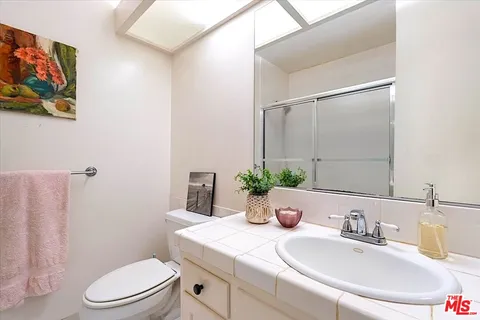 a bathroom with a sink a toilet a mirror and vanity
