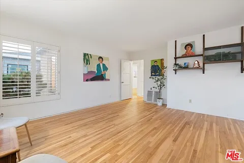 a view of a livingroom with wooden floor and furniture