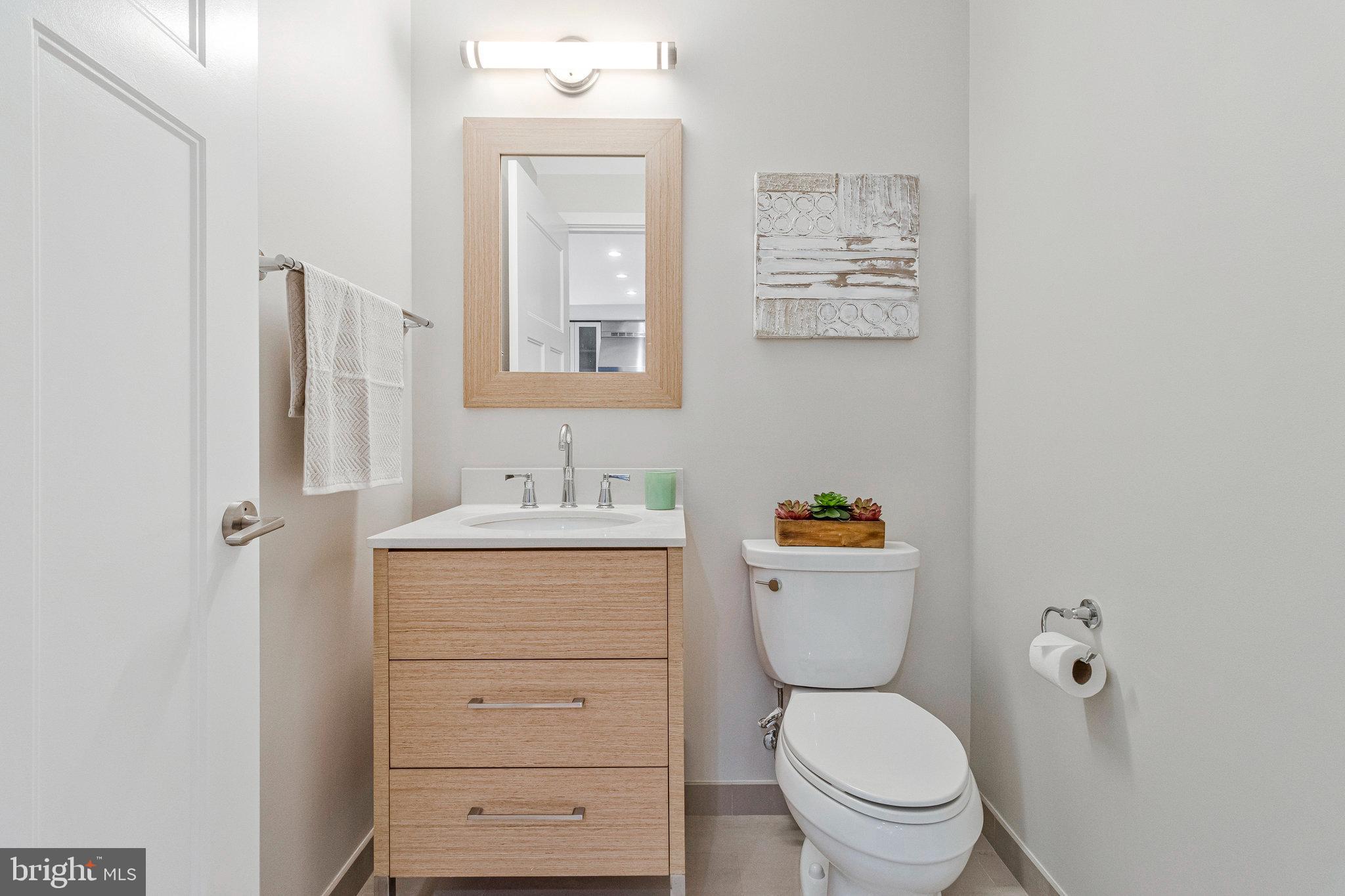 1610 North Queen Street, Unit 211 Arlington, VA 22209 - Photo 12 of 43 a bathroom with a toilet a sink and mirror