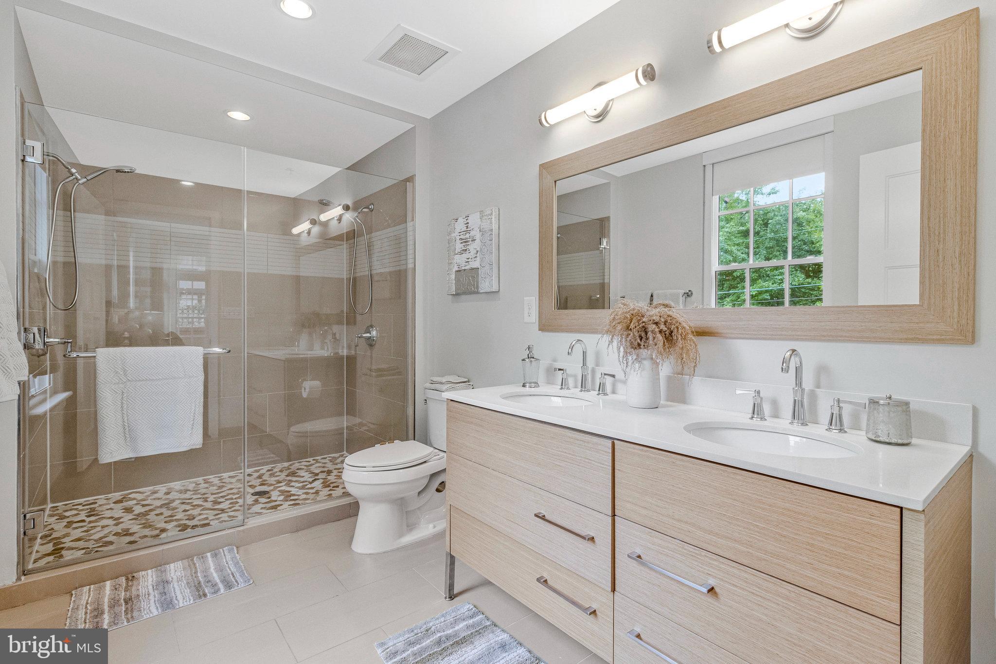 1610 North Queen Street, Unit 211 Arlington, VA 22209 - Photo 22 of 43 a bathroom with a double vanity sink toilet and shower