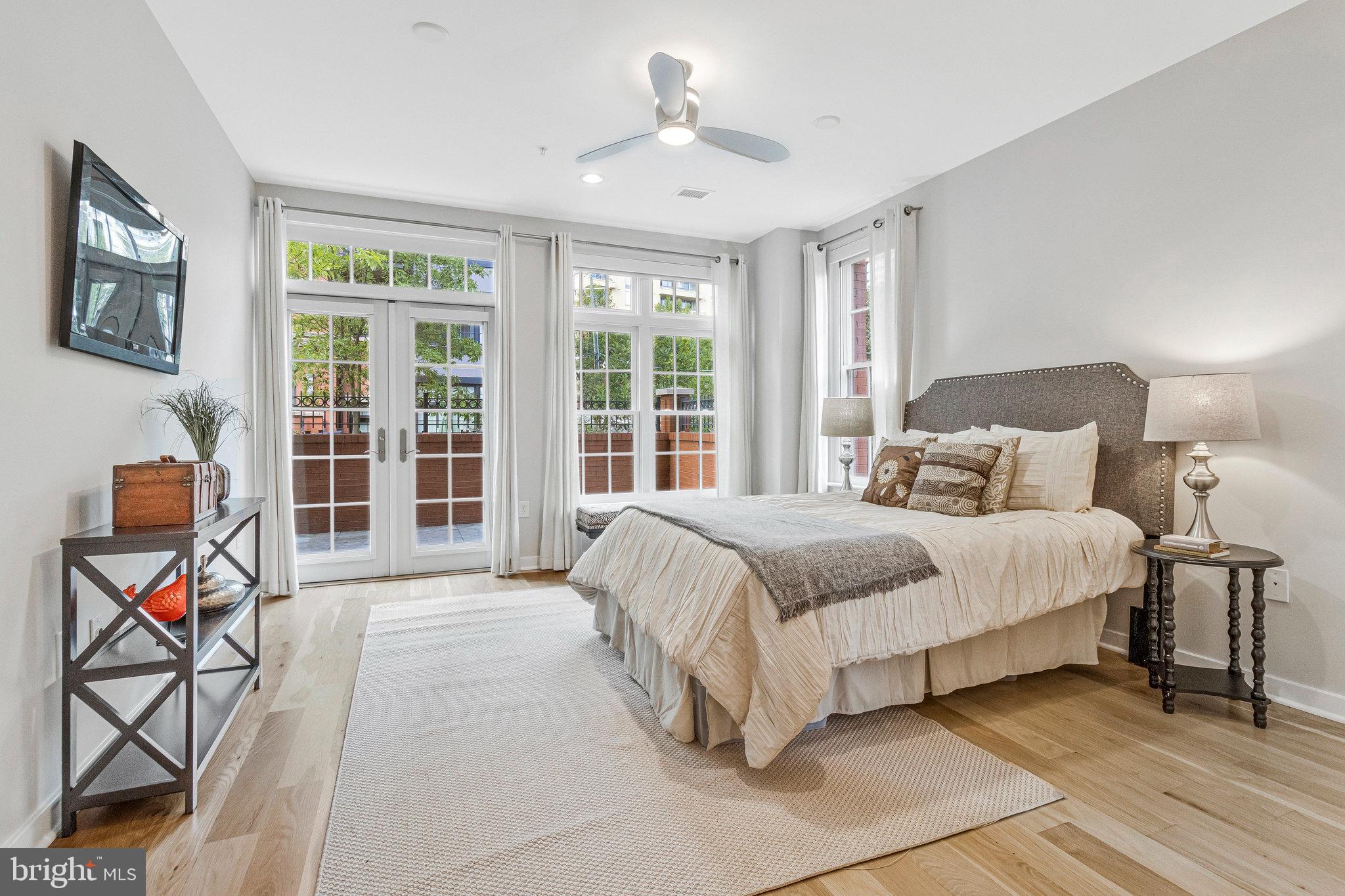 1610 North Queen Street, Unit 211 Arlington, VA 22209 - Photo 25 of 43 a spacious bedroom with a bed and glass windows