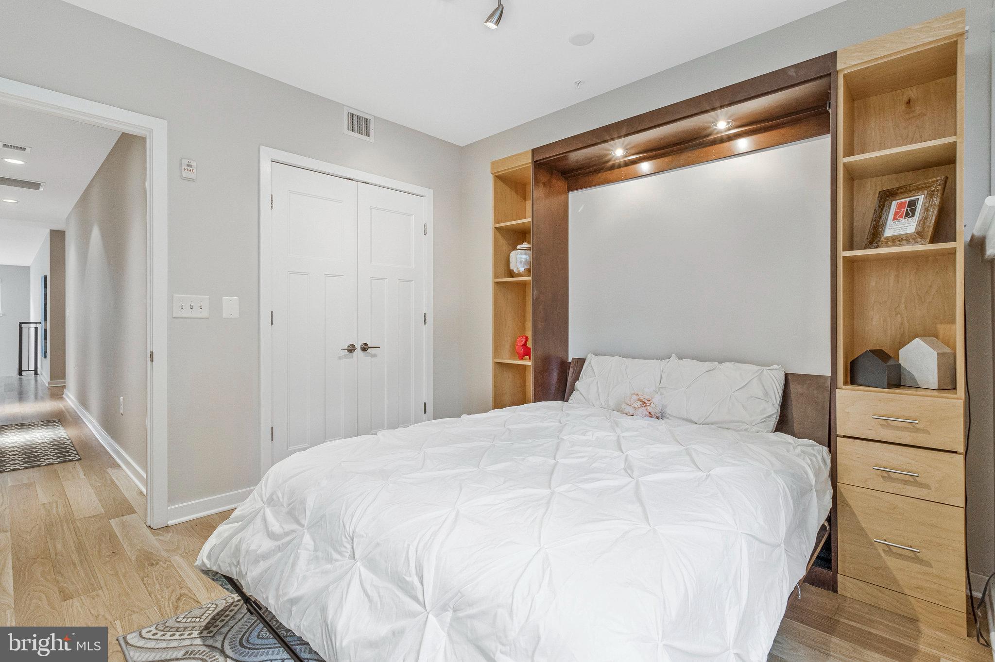 1610 North Queen Street, Unit 211 Arlington, VA 22209 - Photo 30 of 43 a bedroom with a bed and a mirror