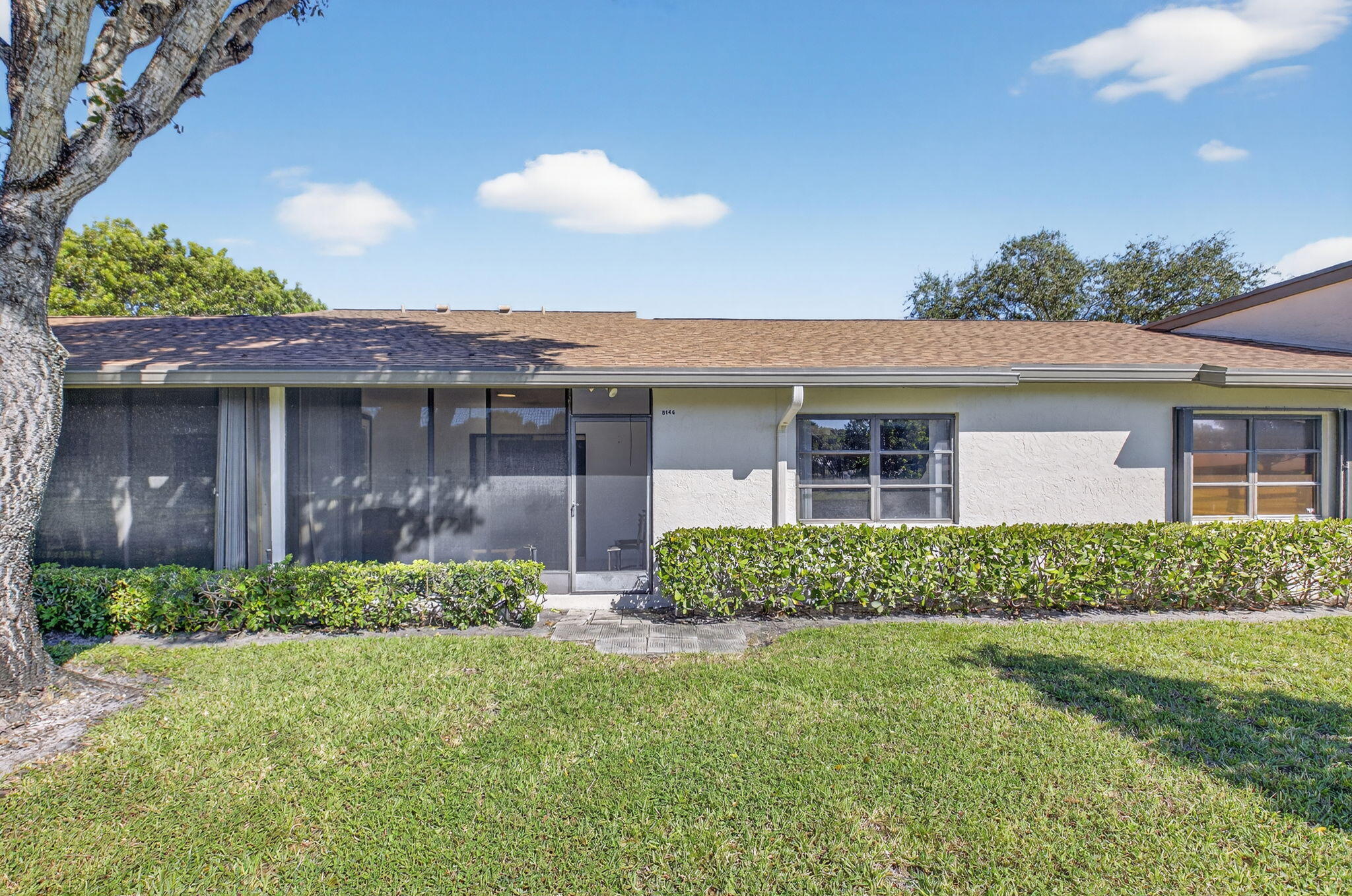 8146 Windgate Drive Boca Raton, FL 33496 - Photo 15 of 24 a front view of a house with a garden