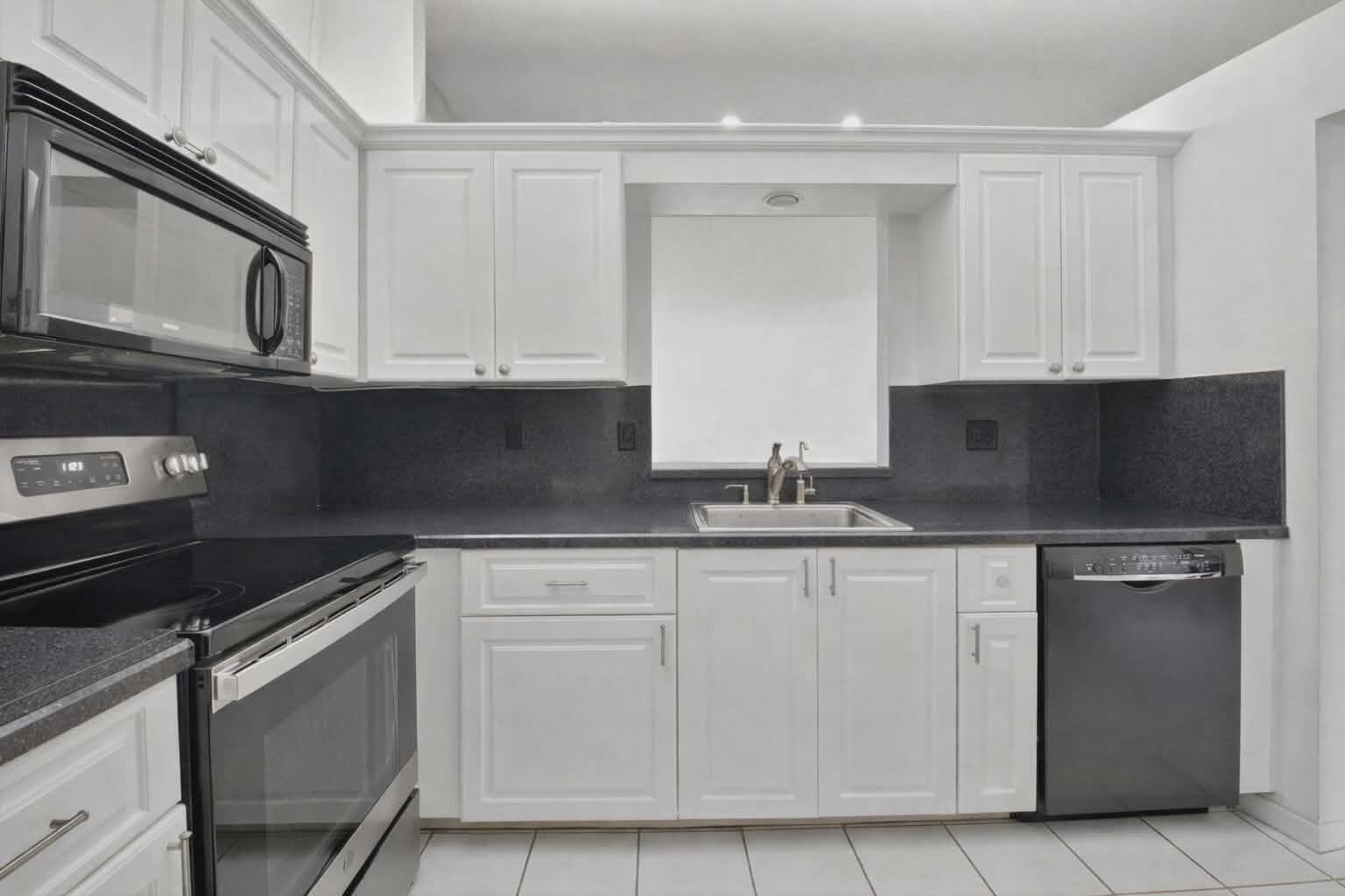 8146 Windgate Drive Boca Raton, FL 33496 - Photo 5 of 24 a kitchen with granite countertop white cabinets and stainless steel appliances