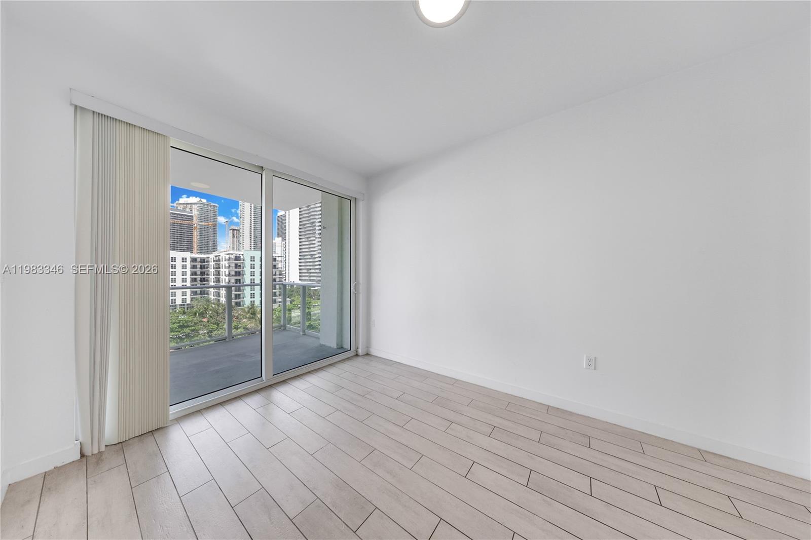321 Northeast 26th Street, Unit 701 Miami, FL 33137 - Photo 12 of 24 a view of an empty room with wooden floor and a window