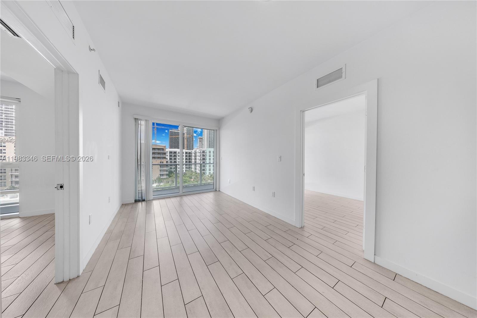321 Northeast 26th Street, Unit 701 Miami, FL 33137 - Photo 16 of 24 a view of an empty room with wooden floor and a window