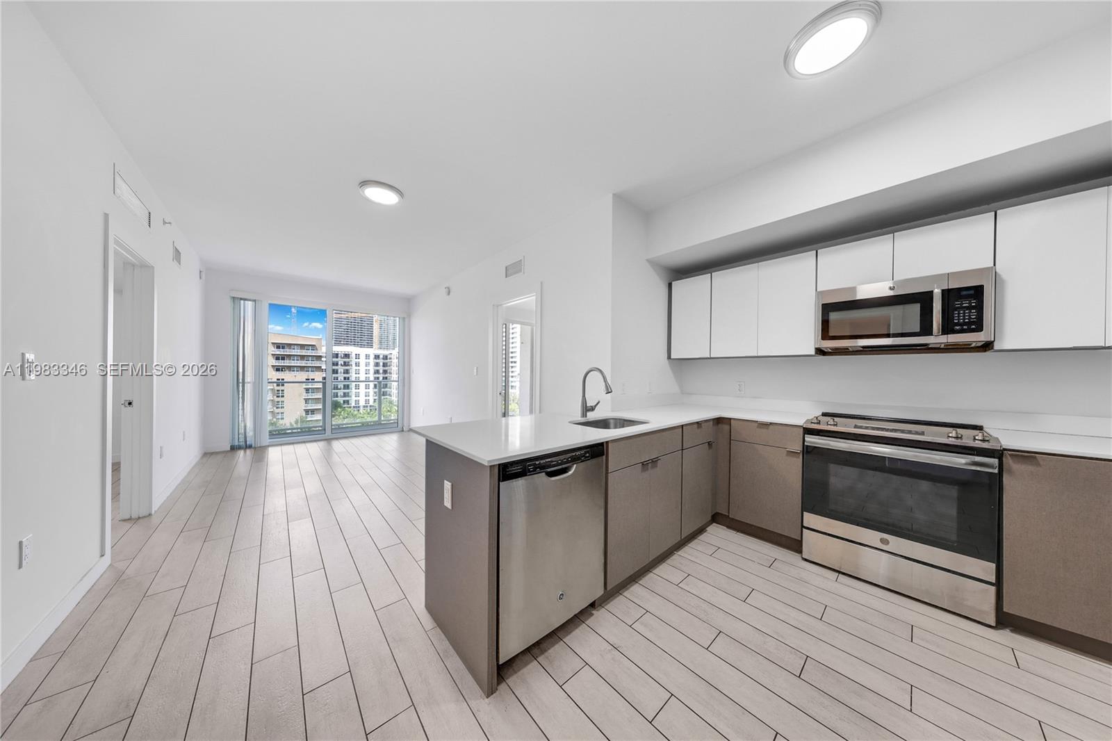 321 Northeast 26th Street, Unit 701 Miami, FL 33137 - Photo 8 of 24 a kitchen with stainless steel appliances granite countertop a stove a sink and a microwave