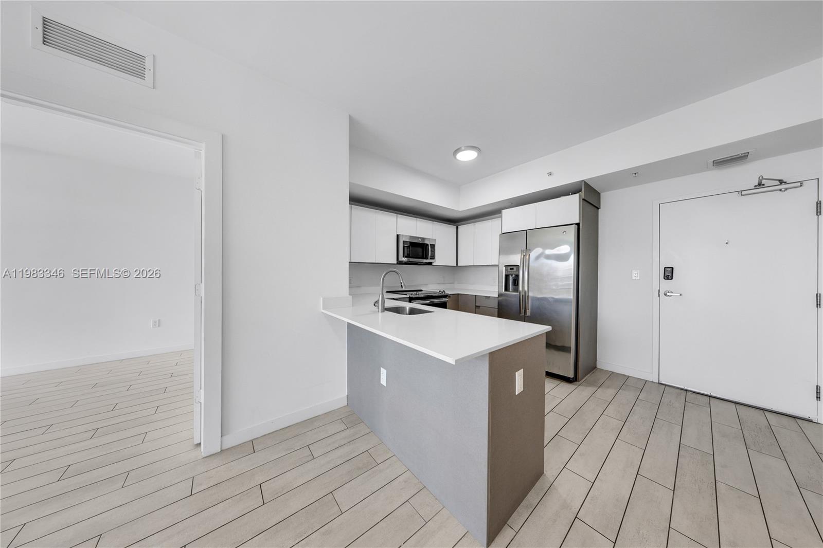 321 Northeast 26th Street, Unit 701 Miami, FL 33137 - Photo 9 of 24 a kitchen with a sink and a refrigerator