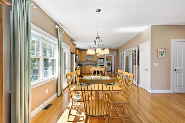 a view of a dining room with furniture a chandelier and wooden floor
