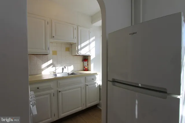 a kitchen with white cabinets and white appliances