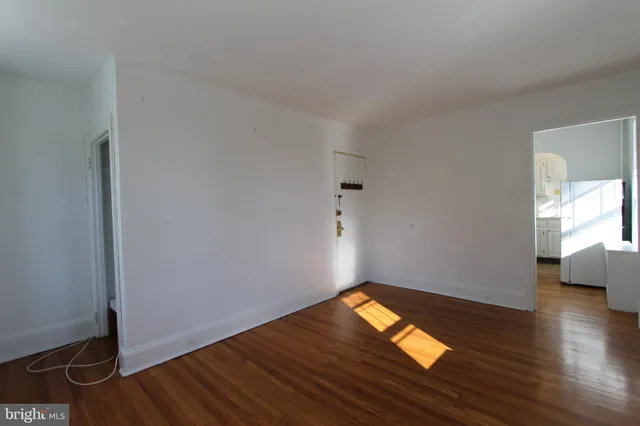 a view of empty room with wooden floor
