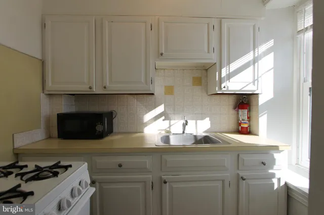 a kitchen with white cabinets and a stove