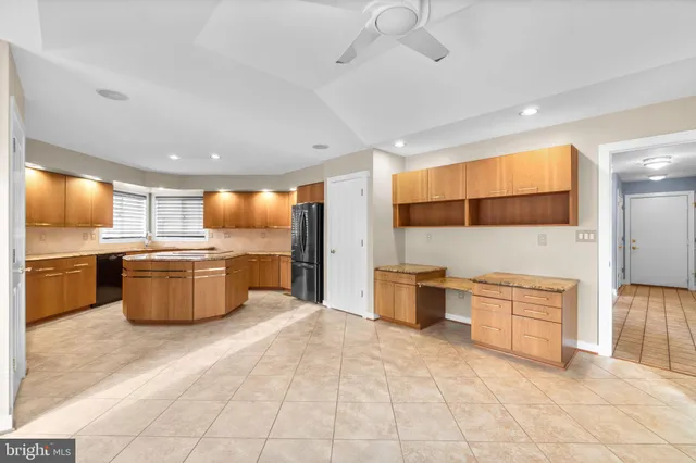 a large kitchen with stainless steel appliances a large counter top a stove and a sink