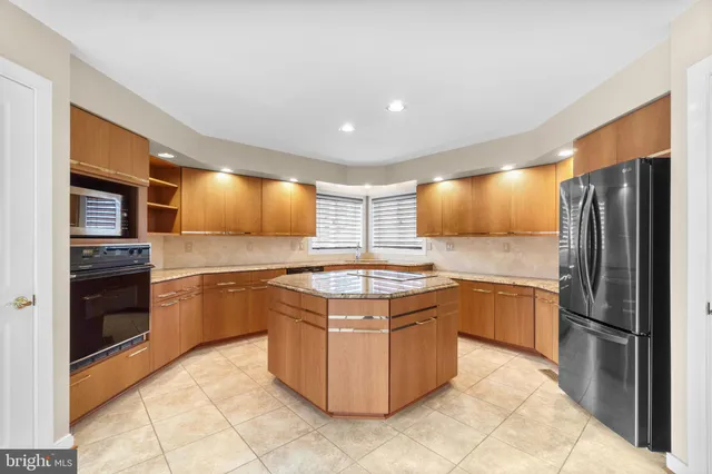 a kitchen with stainless steel appliances granite countertop a stove a refrigerator and a sink