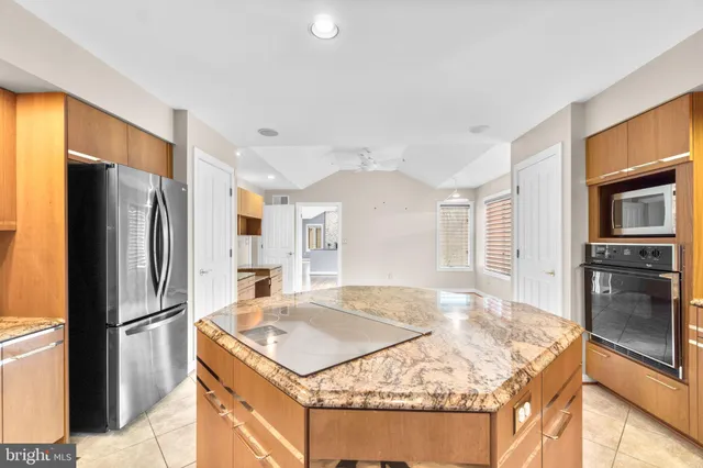 a kitchen with stainless steel appliances granite countertop a sink and a refrigerator