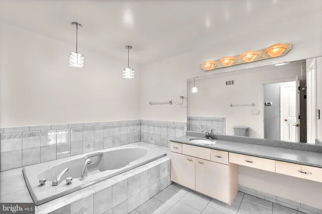 a bathroom with a bathtub a double vanity sink and a mirror