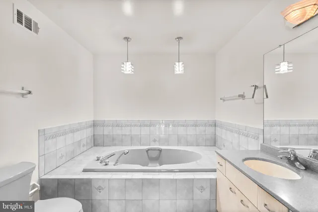 a bathroom with a tub a sink and mirror