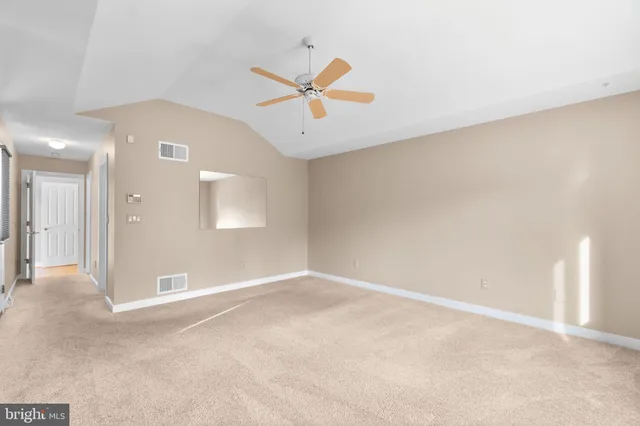 an empty room with closet and a chandelier fan