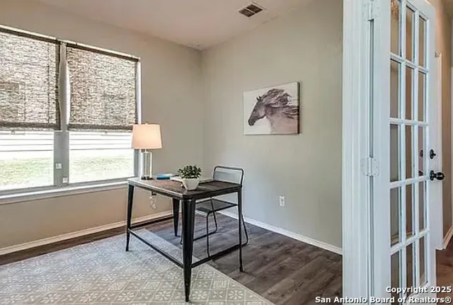 a view of a workspace with furniture and a window