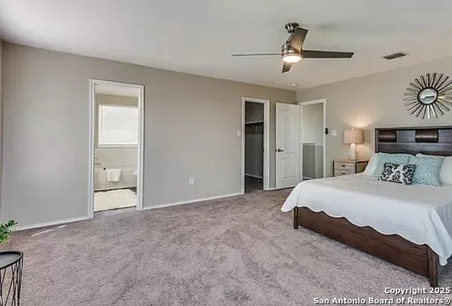 a spacious bedroom with a bed and a ceiling fan