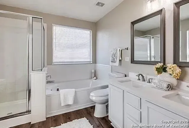 a bathroom with a double vanity sink toilet mirror and window