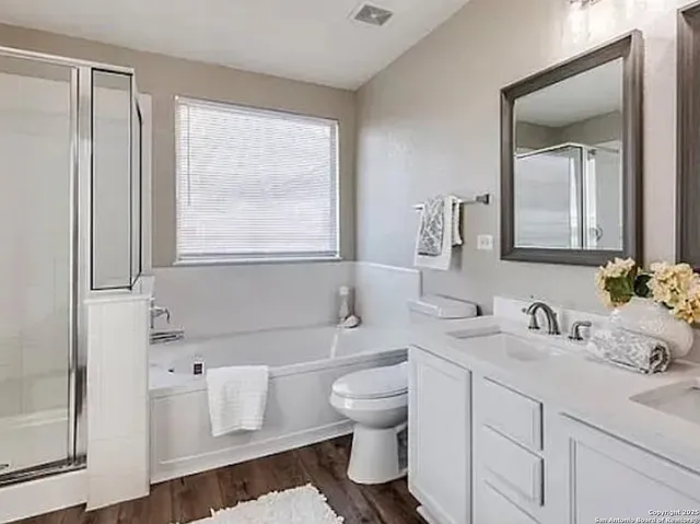 a bathroom with a sink toilet vanity and tub