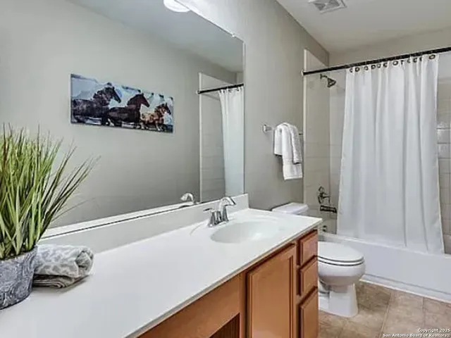 a bathroom with a sink a toilet and a large mirror