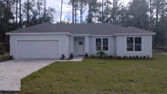 a front view of a house with a garden and yard