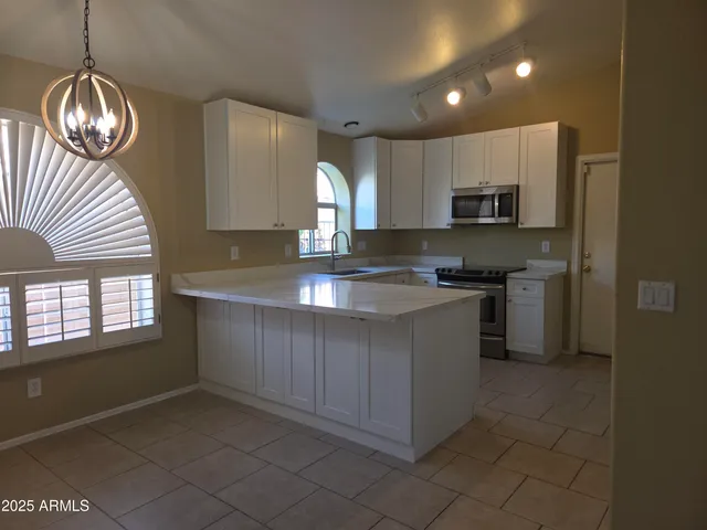 a kitchen with stainless steel appliances a refrigerator a sink a stove and island