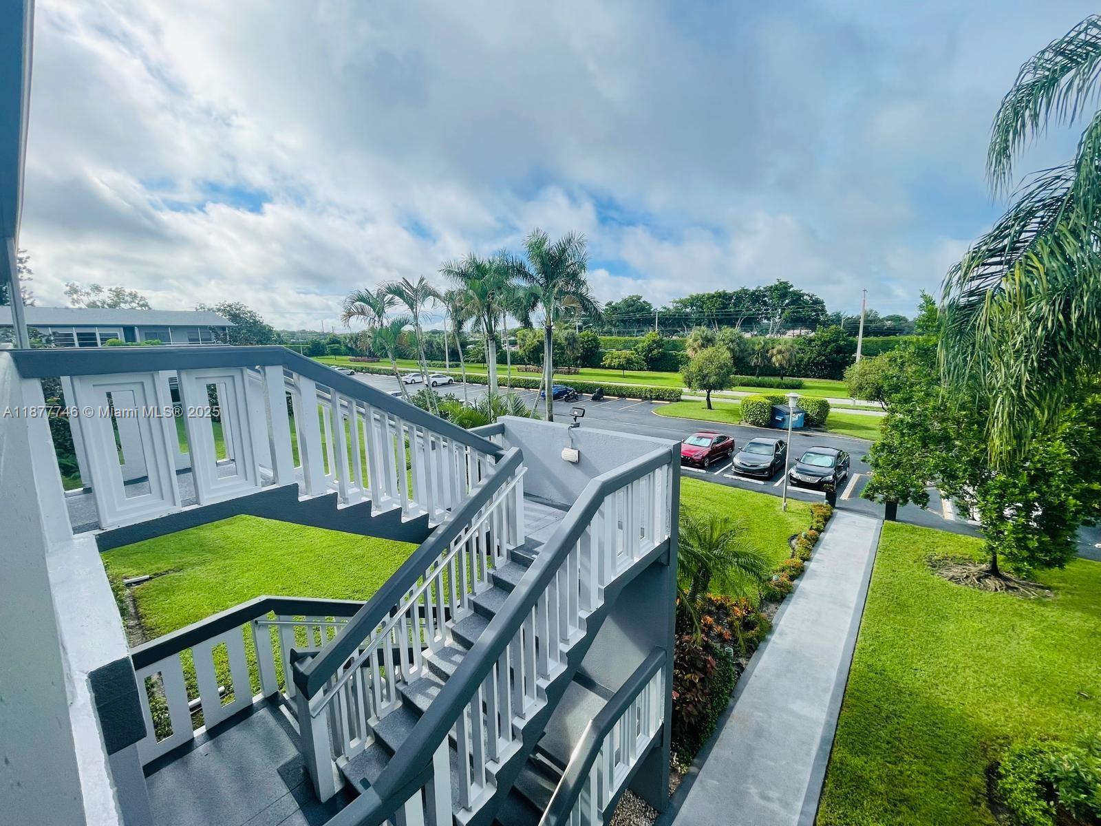 251 Suffolk F, Unit 251 Boca Raton, FL 33434 - Photo 14 of 25 a view of a chair and tables in the backyard