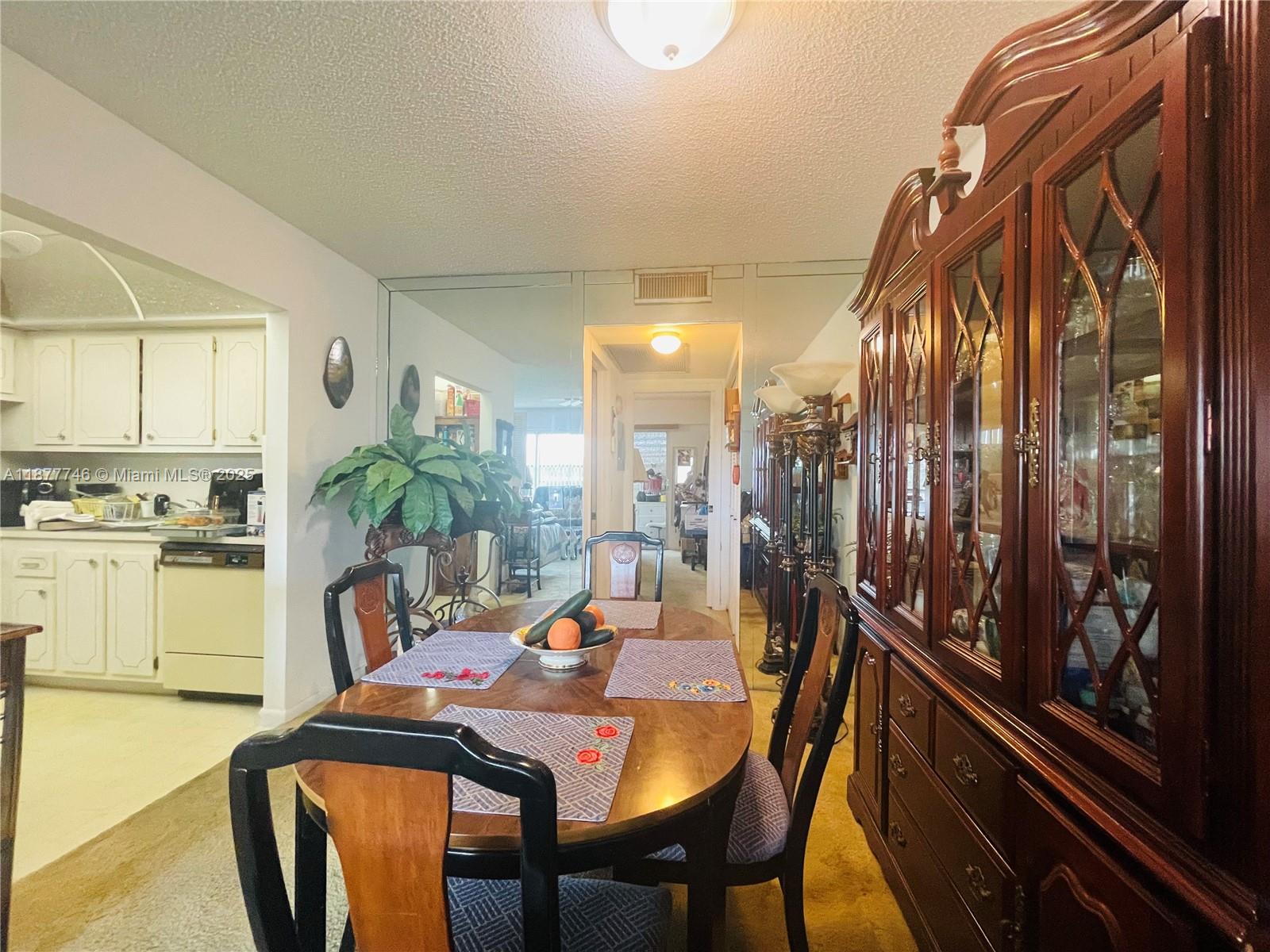 251 Suffolk F, Unit 251 Boca Raton, FL 33434 - Photo 8 of 25 a dining room with furniture and a floor to ceiling window