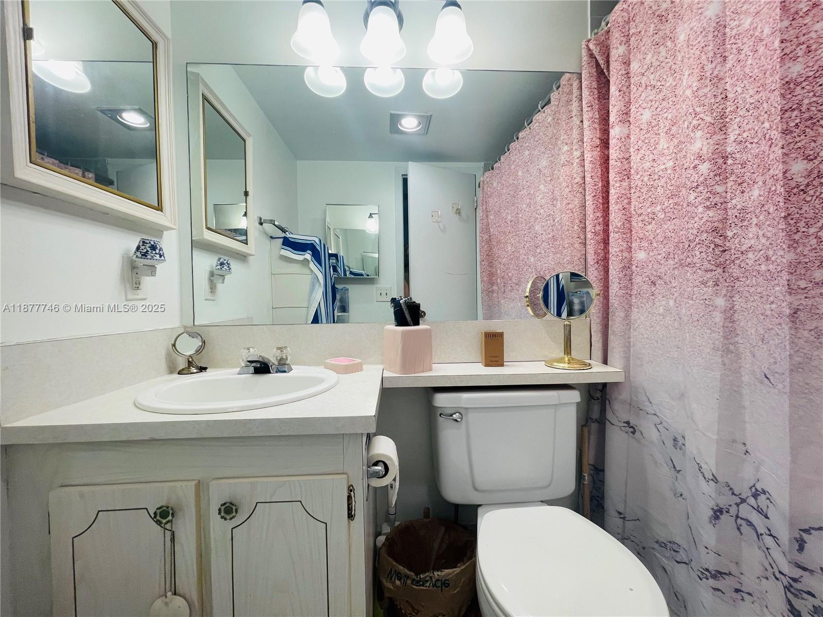 251 Suffolk F, Unit 251 Boca Raton, FL 33434 - Photo 10 of 25 a bathroom with a toilet sink and mirror